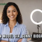 Professional webcam model Gia Sunny smiling in her modern content creator workspace.