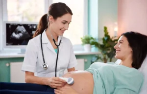 Obstetrician doctor examining pregnant patient in modern clinic, representing Obstetrika care during pregnancy
