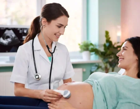 Obstetrician doctor examining pregnant patient in modern clinic, representing Obstetrika care during pregnancy